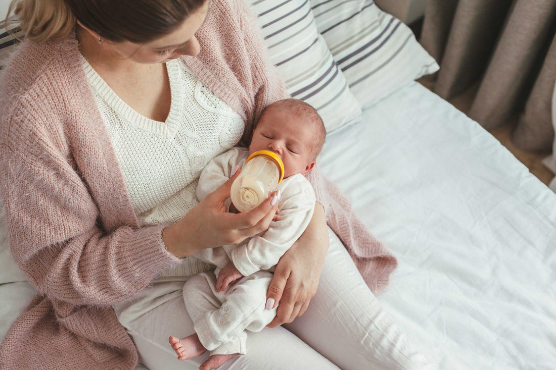 Mama gibt dem Baby ein Fläschchen