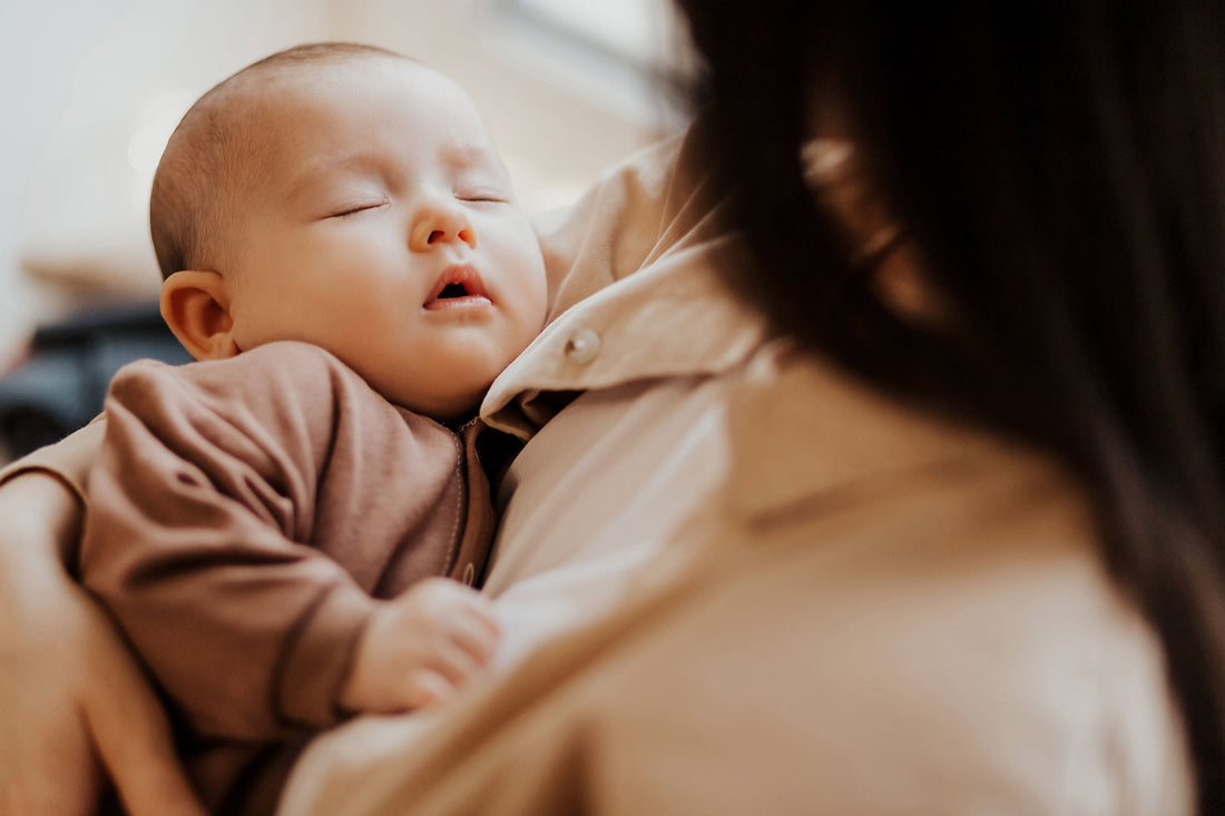 Baby liegt im Arm der Mama